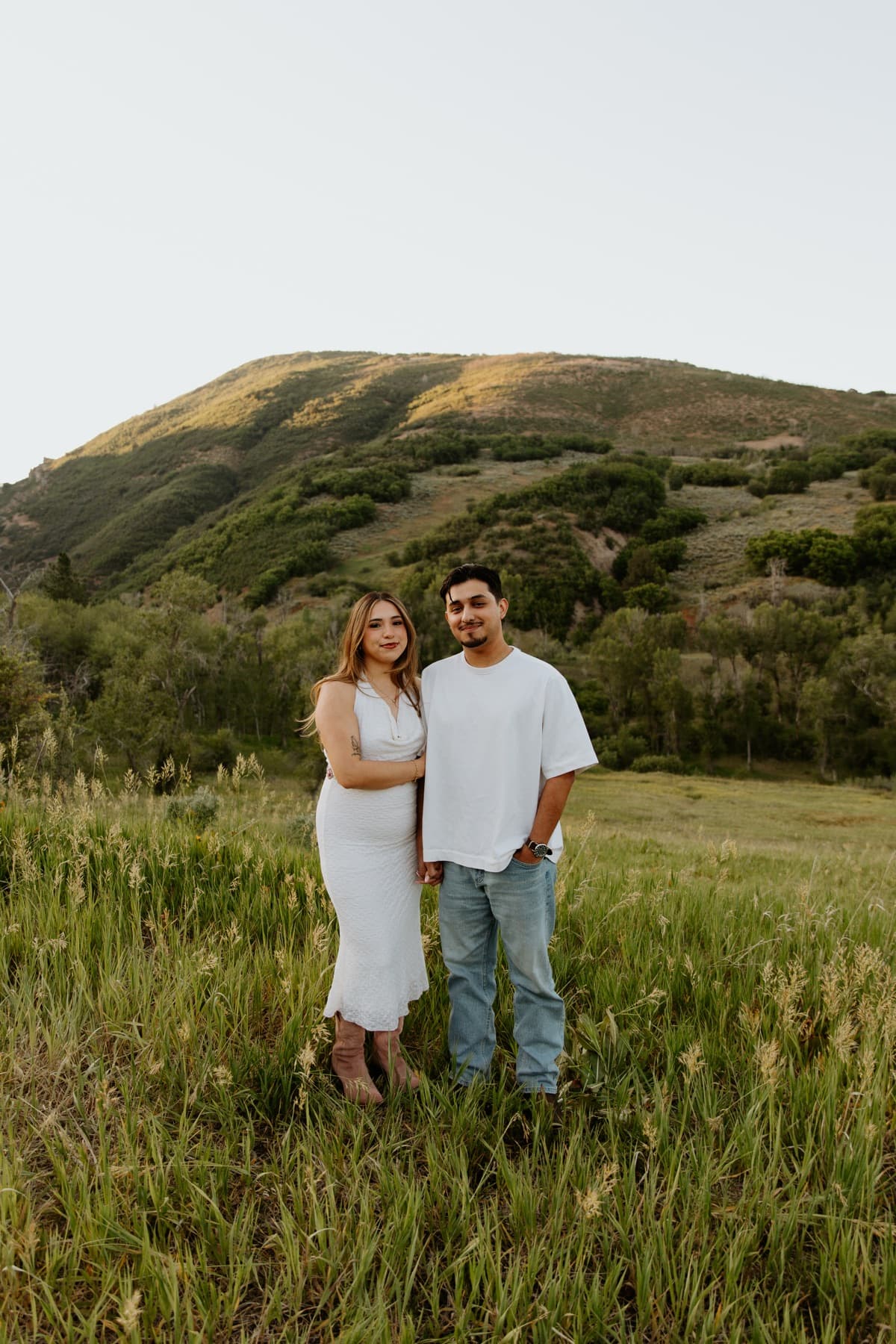 Alex and Serena standing together in a mountain meadow